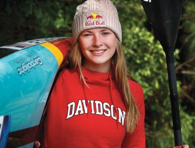 davidson student olympian kayaker poses with kayak