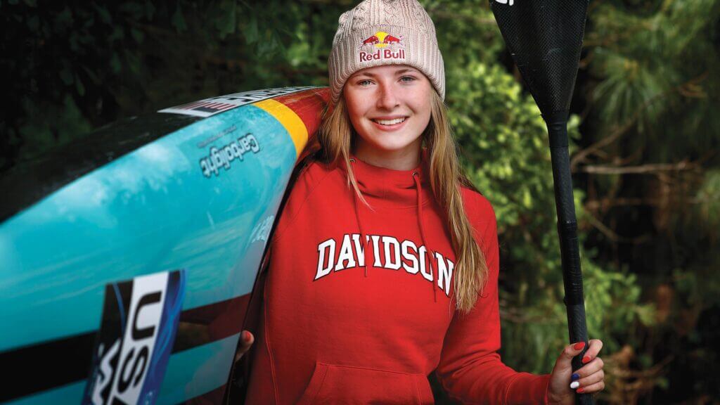 davidson student olympian kayaker poses with kayak