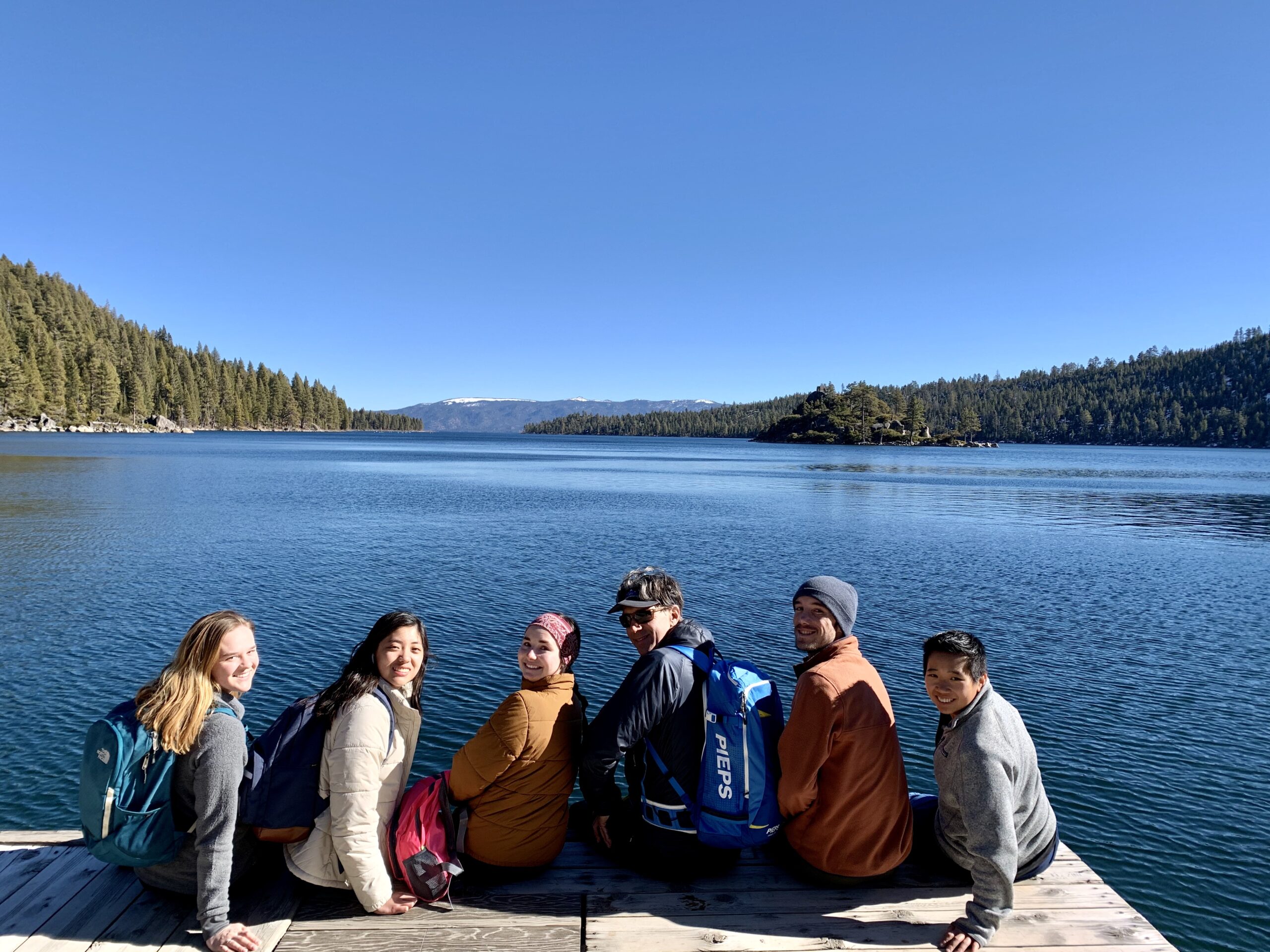 students sitting on dock on lake tahoe